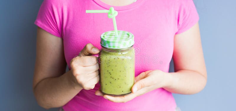 Gezonde groene smoothie in vrouwen` s hand Veganist, ruw voedsel, detox en dieetlevensstijl stock afbeelding Gezonde groene smoothie in vrouwen` s hand Veganist, ruw voedsel, detox en dieetlevensstijl stock afbeelding