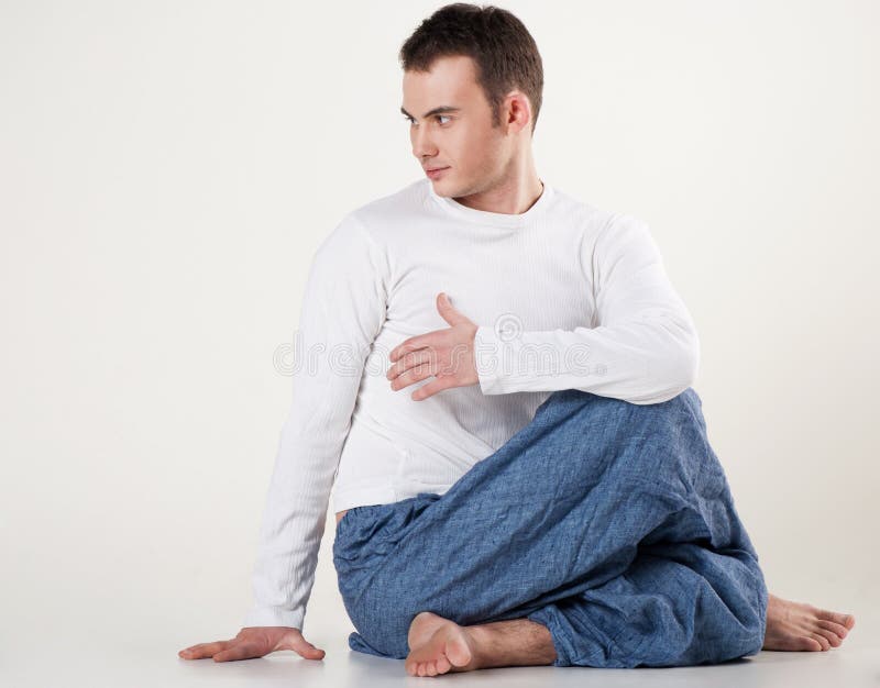 Gezonde jonge mens die yoga doet. Het verdraaien van de stekel stelt royalty-vrije stock foto Gezonde jonge mens die yoga doet. Het verdraaien van de stekel stelt royalty-vrije stock foto