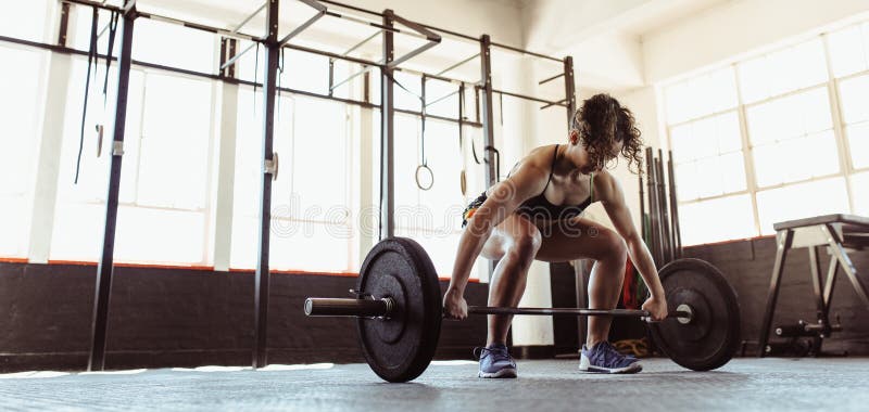 Gezonde jonge vrouw die een barbell opheffen stock afbeelding Gezonde jonge vrouw die een barbell opheffen stock afbeelding