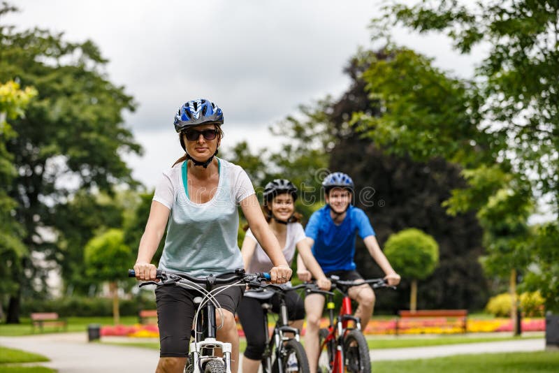 Gezonde levensstijl - mensen die fietsen in stadspark berijden stock foto Gezonde levensstijl - mensen die fietsen in stadspark berijden stock foto
