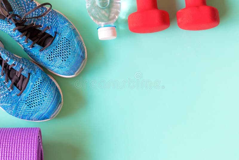 Gezonde levensstijl voor vrouwendieet met sportmateriaal, tennisschoenen, matyoga en fles water op groene achtergrond stock fotografie Gezonde levensstijl voor vrouwendieet met sportmateriaal, tennisschoenen, matyoga en fles water op groene achtergrond stock fotografie