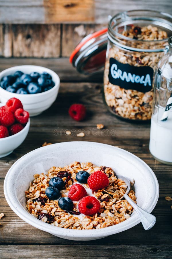 Gezonde ontbijtkom Eigengemaakte granola met natuurlijke yoghurt, bosbessen en frambozen stock afbeeldingen Gezonde ontbijtkom Eigengemaakte granola met natuurlijke yoghurt, bosbessen en frambozen stock afbeeldingen
