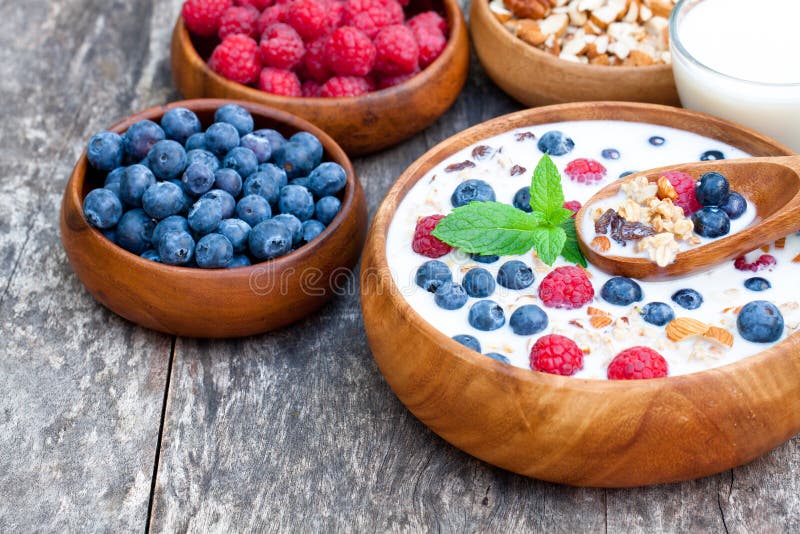 Gezonde ontbijtmuesli met bessen en melk in houten plaat royalty-vrije stock foto's Gezonde ontbijtmuesli met bessen en melk in houten plaat royalty-vrije stock foto's