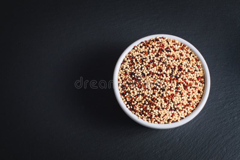 Gezonde Quinoa van het voedselconcept Organische ruwe korrelmengeling van 3 kleurenwit, rood en zwarte in witte ceramische kop stock fotografie Gezonde Quinoa van het voedselconcept Organische ruwe korrelmengeling van 3 kleurenwit, rood en zwarte in witte ceramische kop stock fotografie