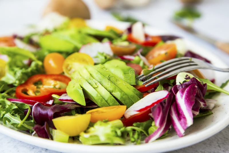 Gezonde salade met bio organische groenten, groene veganistmaaltijd met avocado, peper, radijs, tomaten, sla, kool, de lente royalty-vrije stock foto Gezonde salade met bio organische groenten, groene veganistmaaltijd met avocado, peper, radijs, tomaten, sla, kool, de lente royalty-vrije stock foto