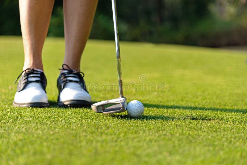 Gezonde sport Sluit nadruk van de Golfspeler omhoog de Aziatische sportieve vrouw zettend golfbal op het groene golf op avondtijd stock afbeeldingen Gezonde sport Sluit nadruk van de Golfspeler omhoog de Aziatische sportieve vrouw zettend golfbal op het groene golf op avondtijd stock afbeeldingen
