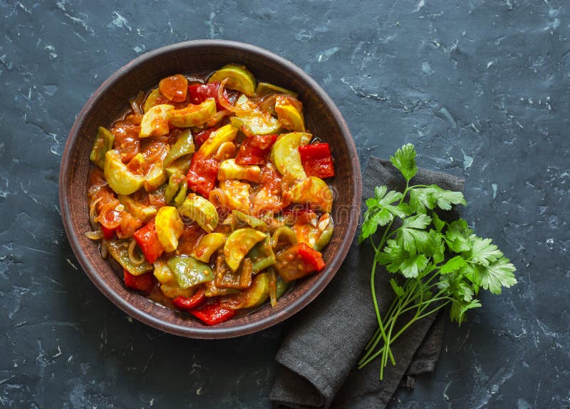 Gezonde vegetarische gestoofde lunch -, gesmoorde tuingroenten Plantaardige Ratatouille Op een donkere achtergrond stock afbeeldingen Gezonde vegetarische gestoofde lunch -, gesmoorde tuingroenten Plantaardige Ratatouille Op een donkere achtergrond stock afbeeldingen