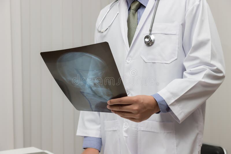 Gezondheidszorg en medisch concept, Arts die hoofd x-ray film in bureau kijken royalty-vrije stock foto's Gezondheidszorg en medisch concept, Arts die hoofd x-ray film in bureau kijken royalty-vrije stock foto's