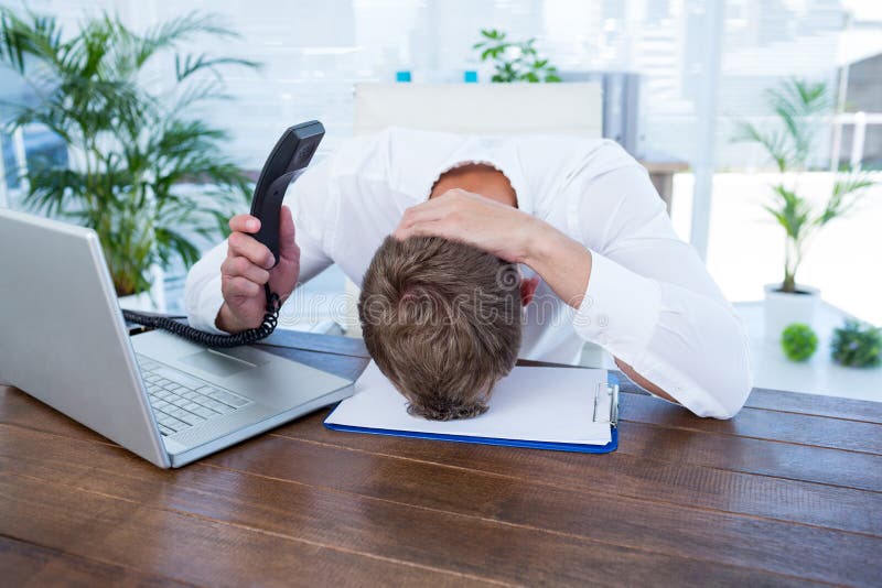 Geïrriteerde zakenman die een telefoon van de landlijn houden stock afbeelding Geïrriteerde zakenman die een telefoon van de landlijn houden stock afbeelding