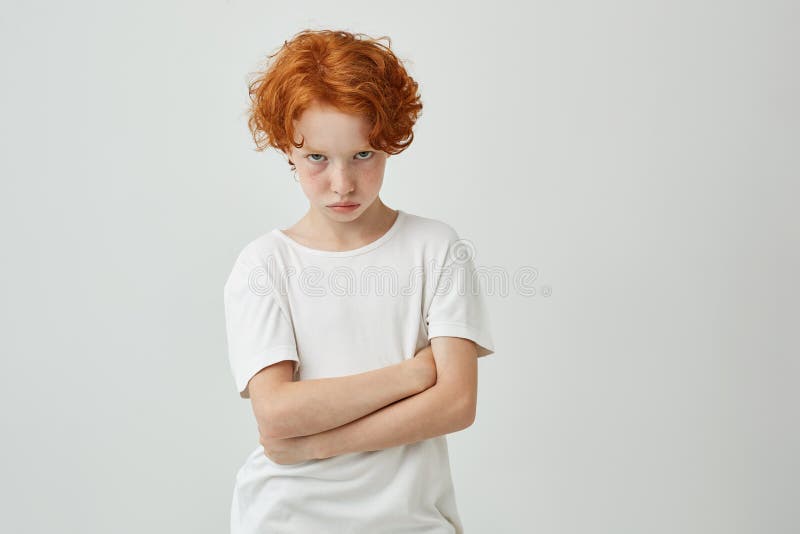 Geïsoleerd portret van ongelukkig weinig jong geitje met rode krullende haar en sproeten die door leraar worden beledigd die slec stock afbeelding Geïsoleerd portret van ongelukkig weinig jong geitje met rode krullende haar en sproeten die door leraar worden beledigd die slec stock afbeelding