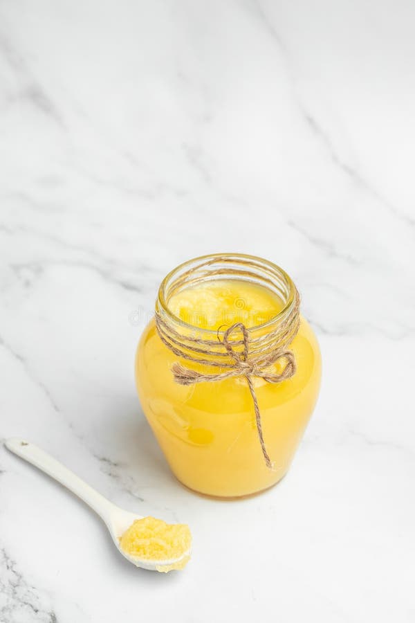 Ghee Oil. Ghee or Clarified Butter in Jar on a Light Background Stock