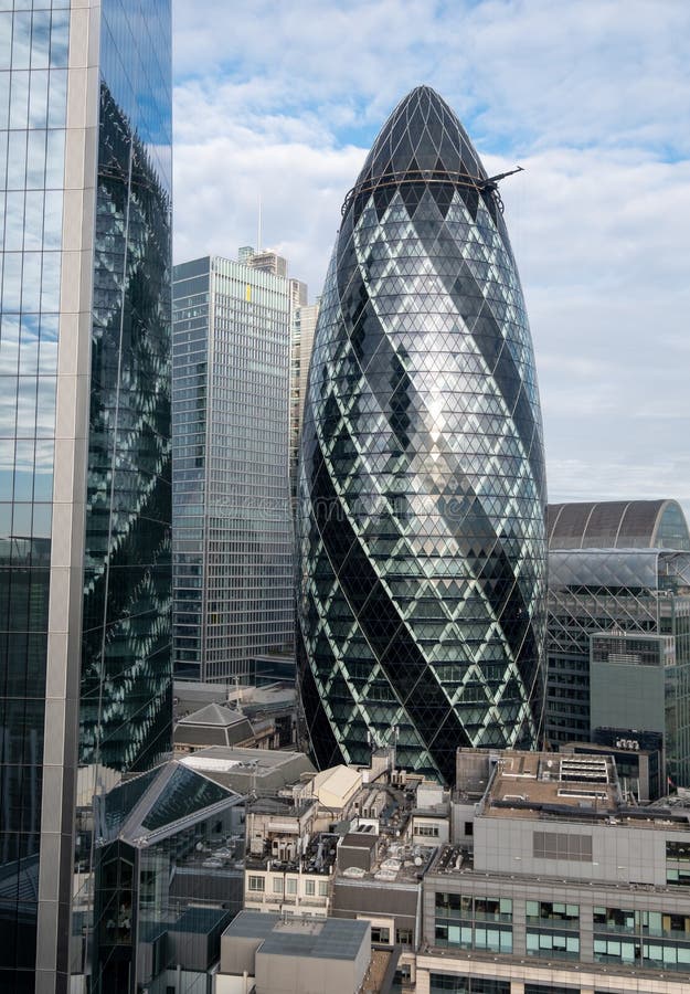 Gherkin Building, 30 St Mary Axe in the City of London financial district, with reflection in adjacent building, London UK