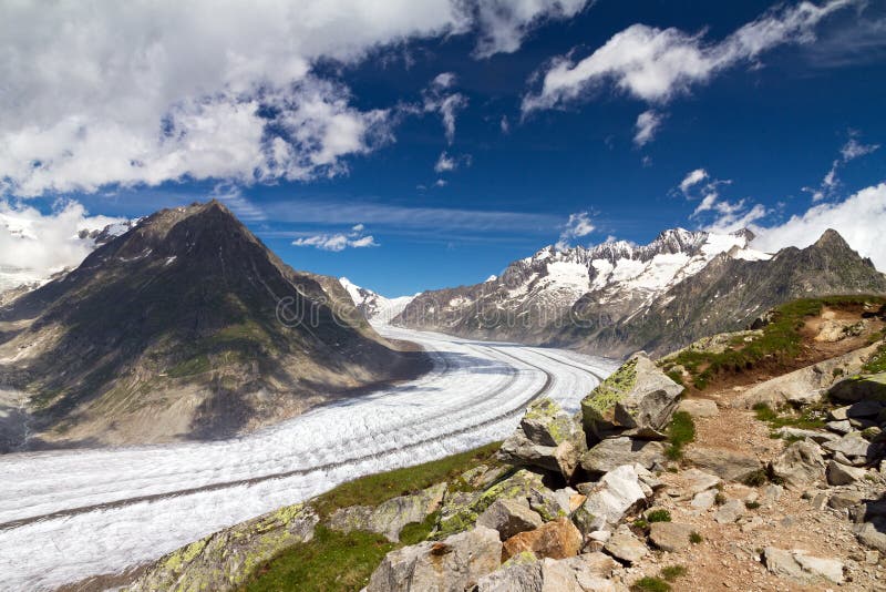 Beautiful panorama of the breathtaking Aletsch glacier as seen from the Bettmer alp in switserland, on a sunny day with clouds in summer. Beautiful panorama of the breathtaking Aletsch glacier as seen from the Bettmer alp in switserland, on a sunny day with clouds in summer