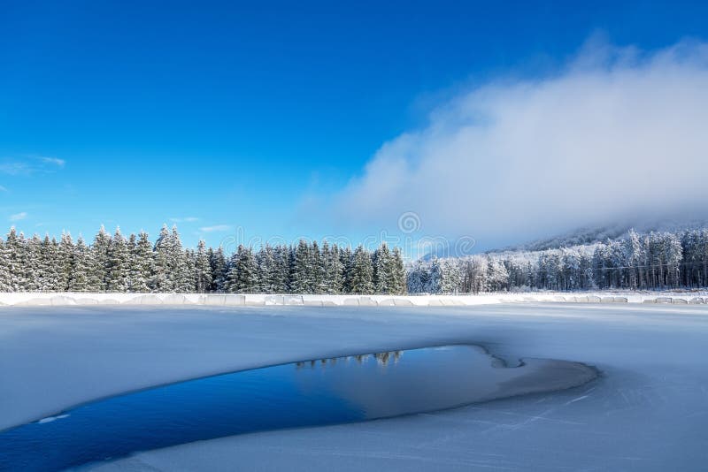 Ghiaccio e crepe blu sulla superficie del ghiaccio Lago congelato sotto un cielo blu nell'inverno fotografie stock libere da diritti Ghiaccio e crepe blu sulla superficie del ghiaccio Lago congelato sotto un cielo blu nell'inverno fotografie stock libere da diritti