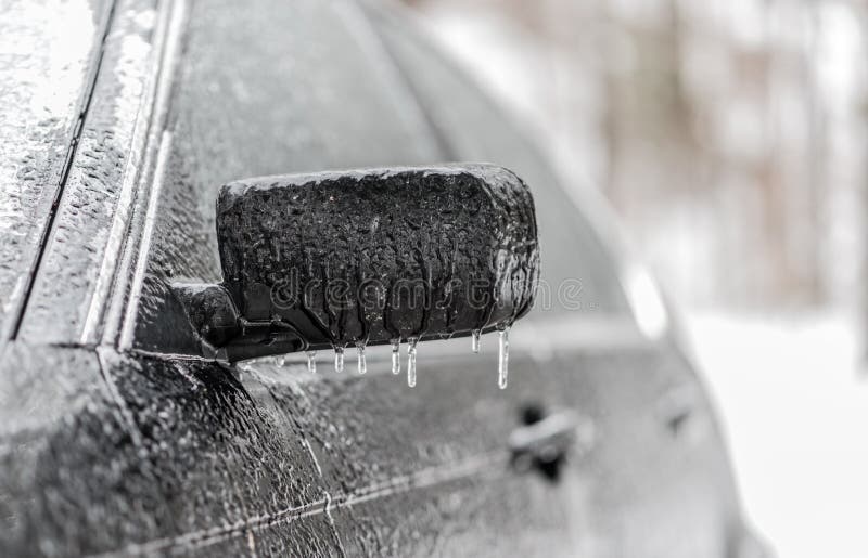 Ghiaccioli che pendono dallo specchio del lato dell'automobile nelle condizioni atmosferiche della pioggia congelantesi Veicolo c immagine stock libera da diritti Ghiaccioli che pendono dallo specchio del lato dell'automobile nelle condizioni atmosferiche della pioggia congelantesi Veicolo c immagine stock libera da diritti
