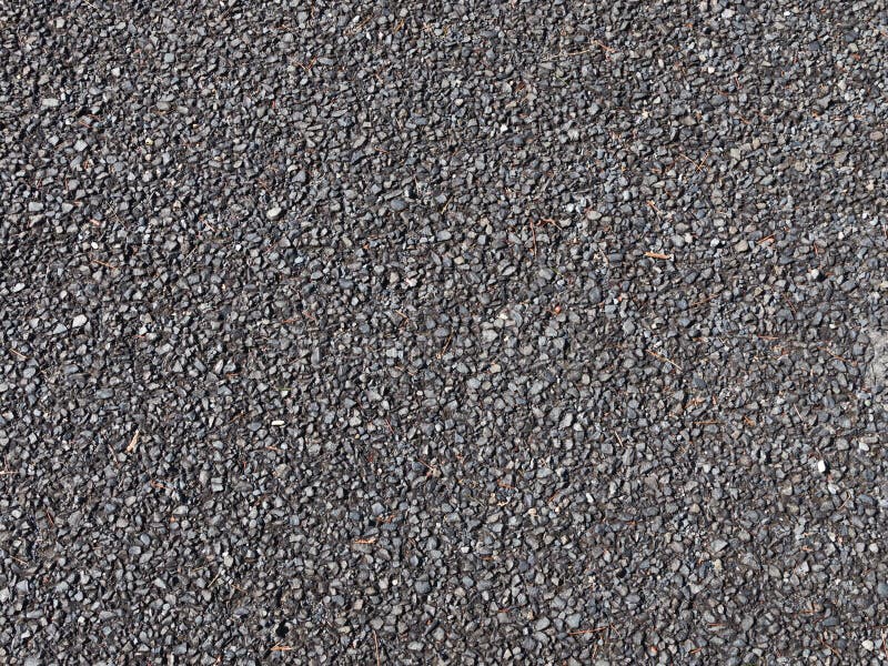 Ghiaia scura sulla strada non asfaltata fotografia stock Ghiaia scura sulla strada non asfaltata fotografia stock