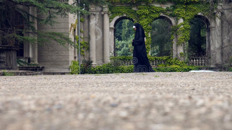 The ghost of a nun walks through the ruins of an old monastery. 4 k. Slow-motion shooting