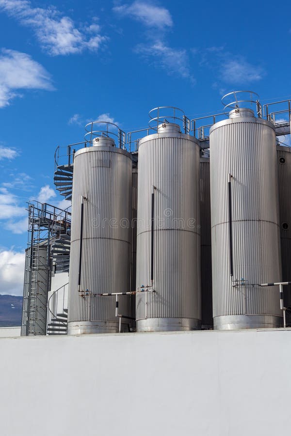 Giant industrial tanks on the bright blue sky