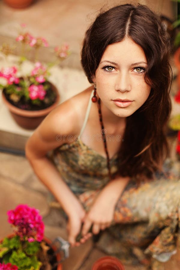 Giardiniere della ragazza con capelli marroni lunghi che tengono uno strumento di giardino immagini stock libere da diritti Giardiniere della ragazza con capelli marroni lunghi che tengono uno strumento di giardino immagini stock libere da diritti