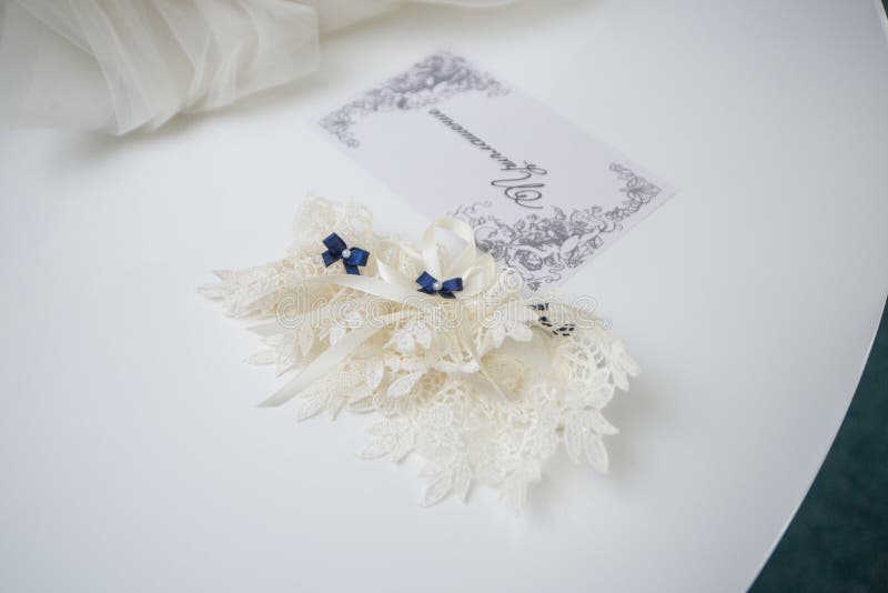Giarrettiera sulla gamba di una sposa, momenti di giorno delle nozze fotografia stock libera da diritti Giarrettiera sulla gamba di una sposa, momenti di giorno delle nozze fotografia stock libera da diritti