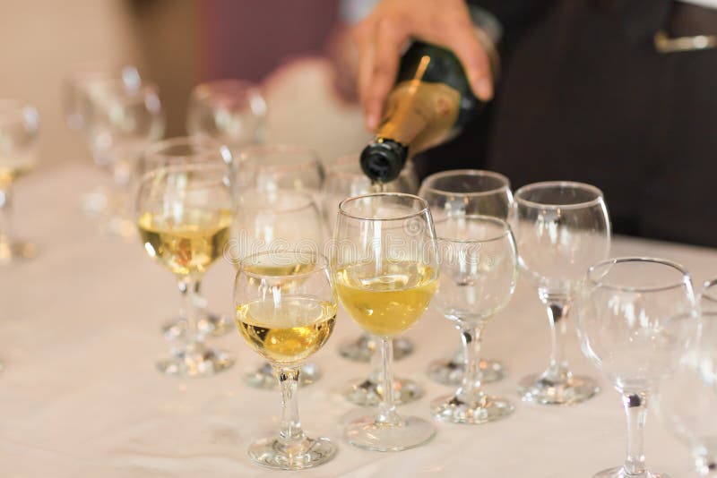 Gietende champagne in fluiten die zich op lijst bevinden royalty-vrije stock afbeelding Gietende champagne in fluiten die zich op lijst bevinden royalty-vrije stock afbeelding