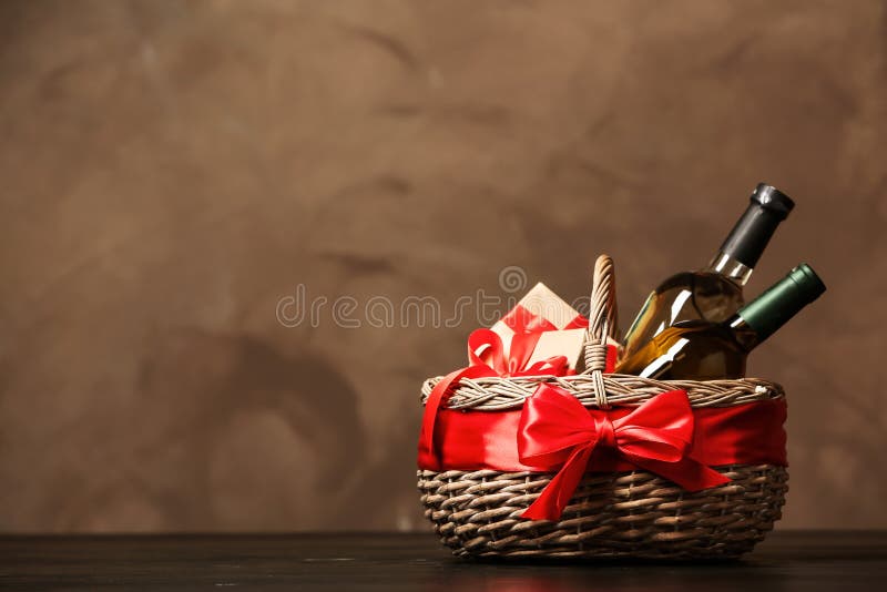 Gift basket with bottles of wine on dark background.