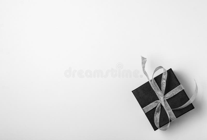Black Gift Box with Silver Ribbon Bow on Black Background Stock Photo