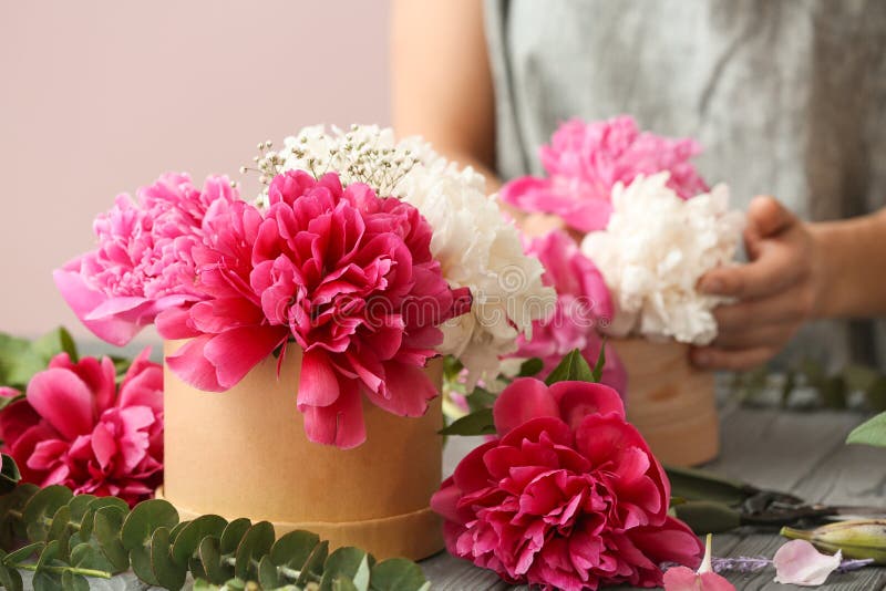 Gift box with beautiful flowers and female florist working at table stock photography Gift box with beautiful flowers and female florist working at table stock photography