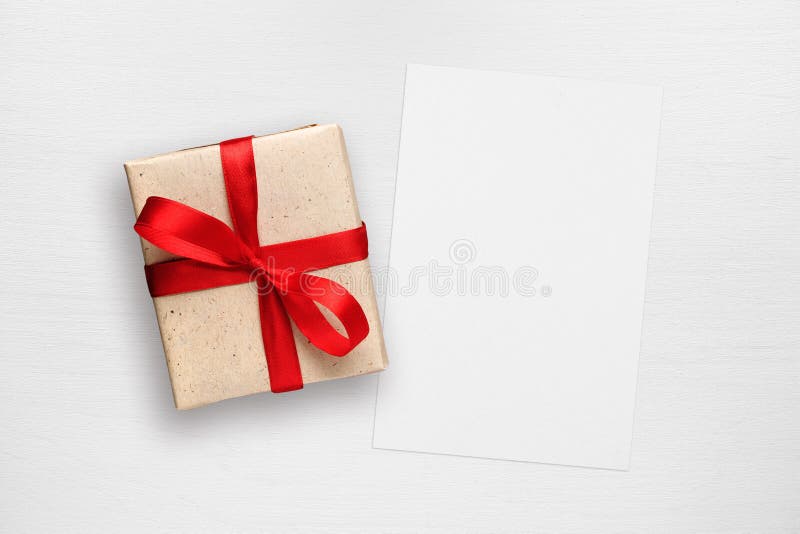 Gift box and greeting card on white table
