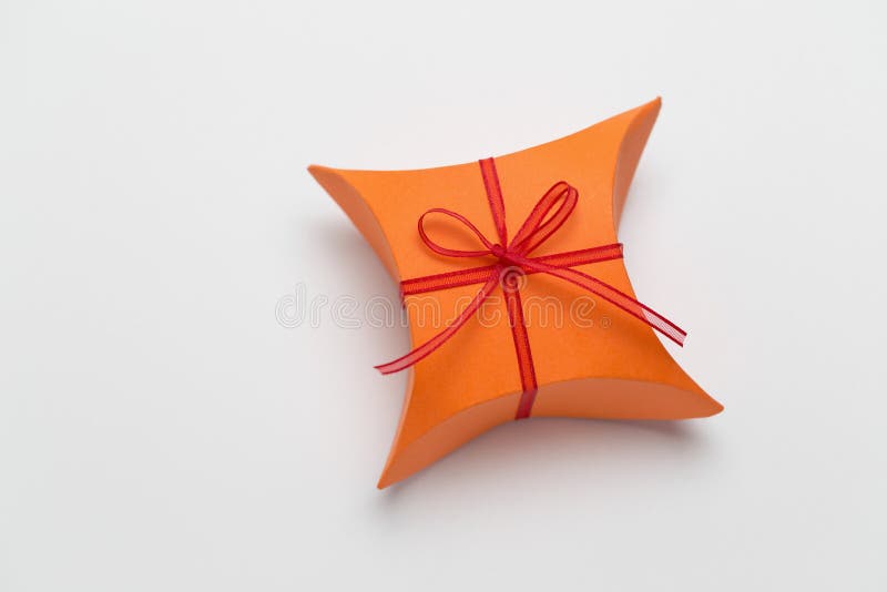 Orange gift box with decorative red ribbon. Cardboard color shapes stock images, royalty-free photos and pictures