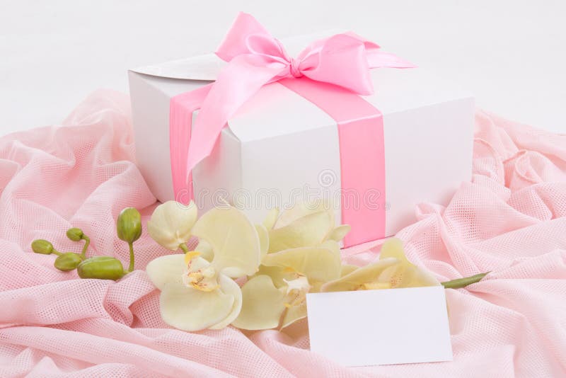 Gift box with pink ribbon, orchid and blank card royalty free stock photo