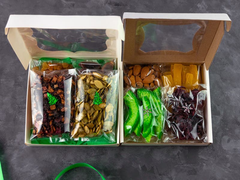 Gift box with set of different dried fruits nuts individually wrapped flat lay. Healthy food diet. Christmas celebration
