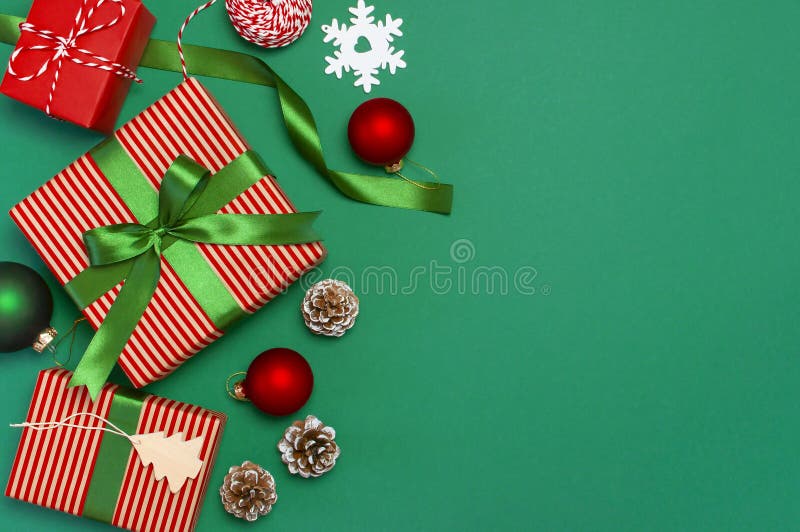 Gift boxes, Christmas balls, toys, fir cones, ribbon on green background. Festive, congratulation, New Year Christmas presents Xma