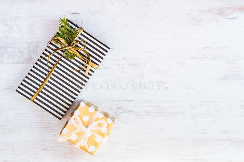 Gift boxes wrapped in black and white striped and golden dotted paper on a white wood background. Christmas presents. Empty space. royalty free stock photography Gift boxes wrapped in black and white striped and golden dotted paper on a white wood background. Christmas presents. Empty space. royalty free stock photography