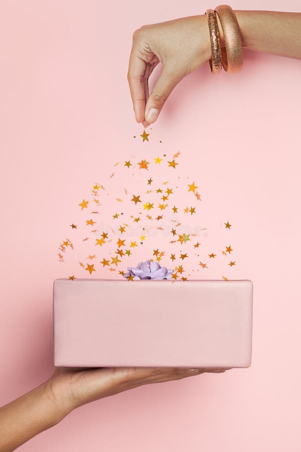 Gift and Falling Confetti Stars on Pastel Pink Background. Minimal