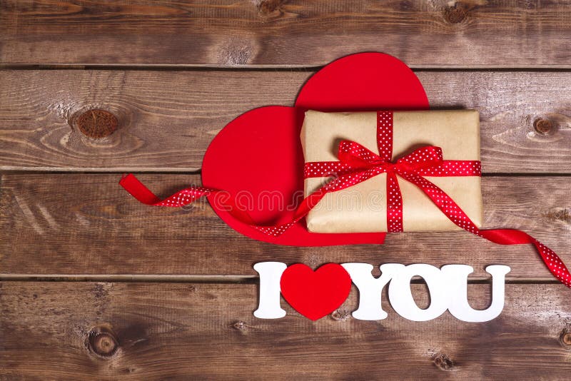 Valentine's Day concept. Gift with red bow on the wooden backgr