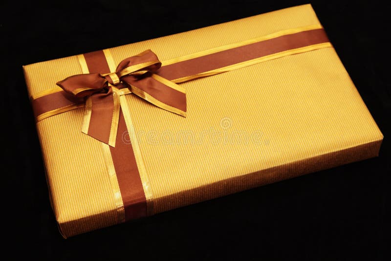 Gift Wrapped In Gold With Brown/gold Ribbon Royalty Free Stock Photo