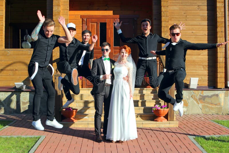 Gifta sig par och att hoppa brudgums vänner arkivfoto Gifta sig par och att hoppa brudgums vänner arkivfoto