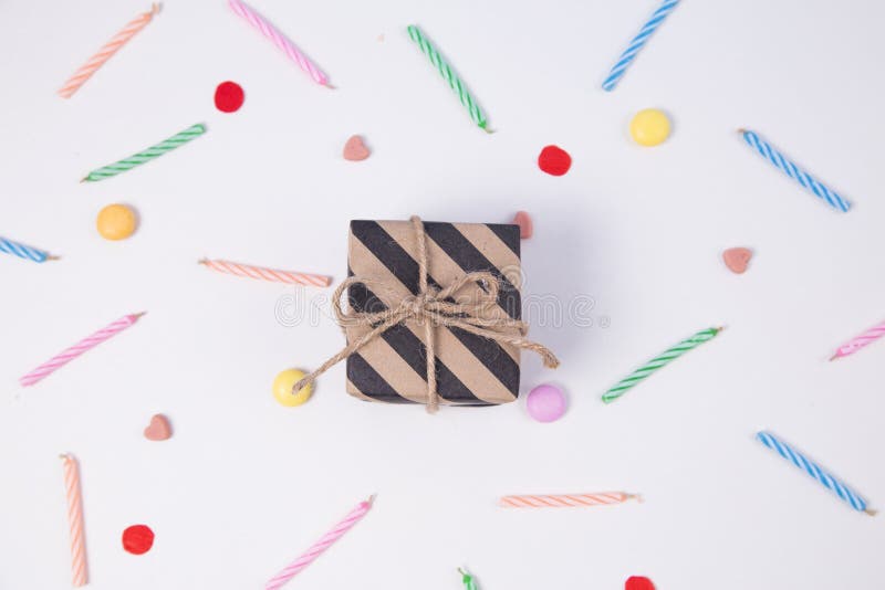 Giftbox with candlesand candy for birthday on pink background.