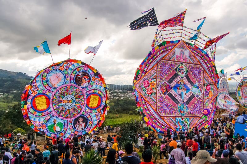 Santiago Sacatepequez, Guatemala - November 1, 2010: Locals display huge circular kites called barriletes & fly smaller ones each year in the cemetery on All Saints' Day to honor spirits of the dead. Santiago Sacatepequez, Guatemala - November 1, 2010: Locals display huge circular kites called barriletes & fly smaller ones each year in the cemetery on All Saints' Day to honor spirits of the dead.