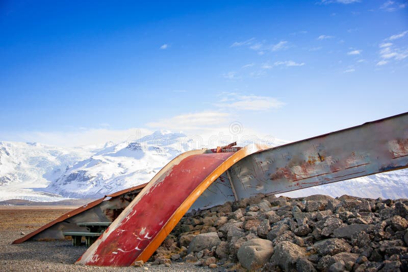 Gigjukvisl bridge remains at Skeidararsandur, Iceland. Twisted metal girders reach towards a blue sky.