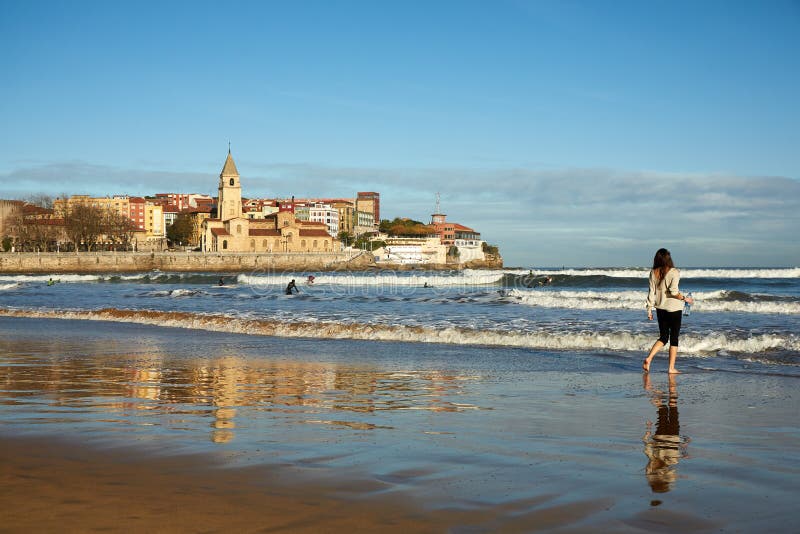 Young woman walking at Gijon beach. travel destination in north of Spain, Europe