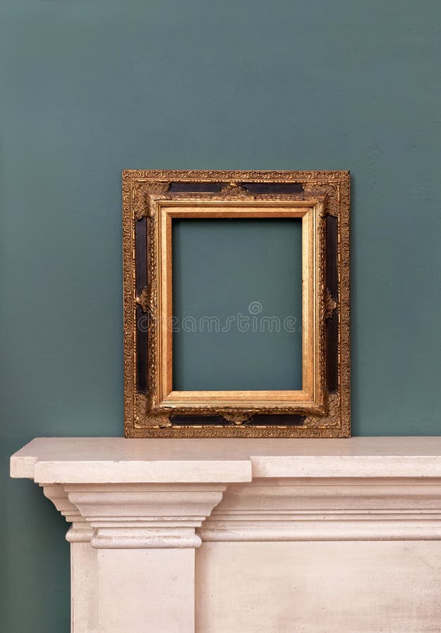Gilded or golden vintage frame on a mantelpiece