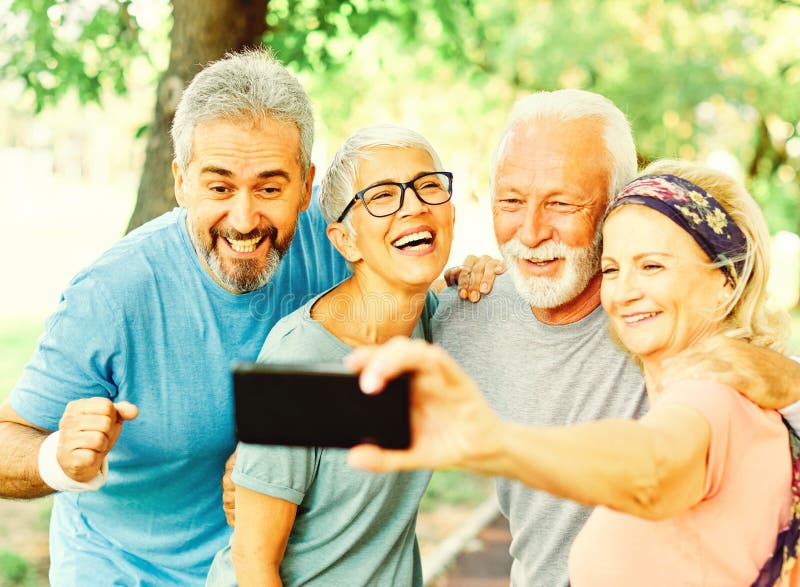 Gimnasio al aire libre mujer hombre estilo de vida deporte activo sano adecuado retiro selfie teléfono móvil. Sonrientes ancianos posando y tomándose selfies juntos en el parque
