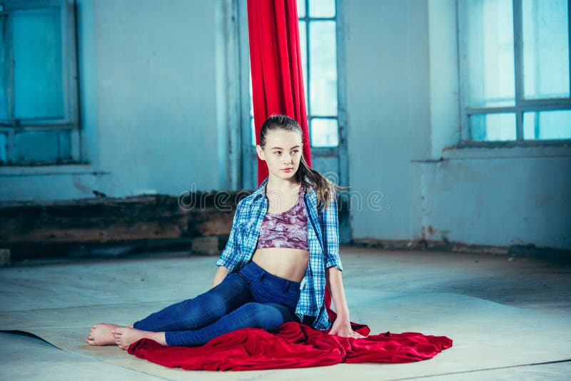 Gimnasta agraciado que descansa después de realizar ejercicio aéreo en el desván fotos de archivo Gimnasta agraciado que descansa después de realizar ejercicio aéreo en el desván fotos de archivo