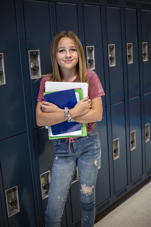 Gimnazjum Studencka pozycja jej szafk? w szkolnym korytarzu fotografia stock Gimnazjum Studencka pozycja jej szafk? w szkolnym korytarzu fotografia stock