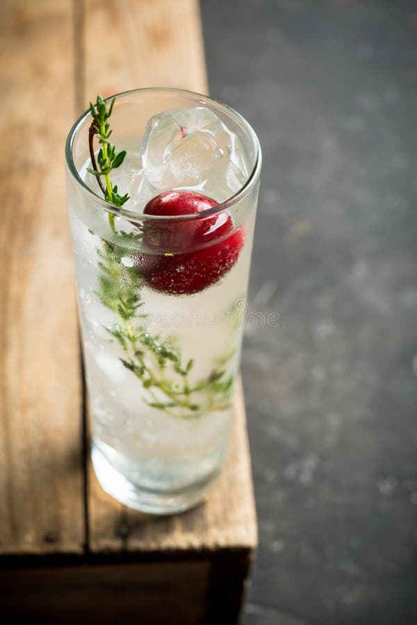 Gin Based Cocktail with Cherries and Thyme Herbs on the Rustic