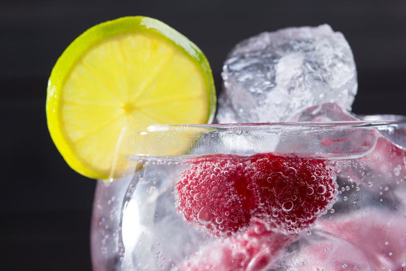 Gin tonic cocktail with raspberry and ice macro closeup royalty free stock photography