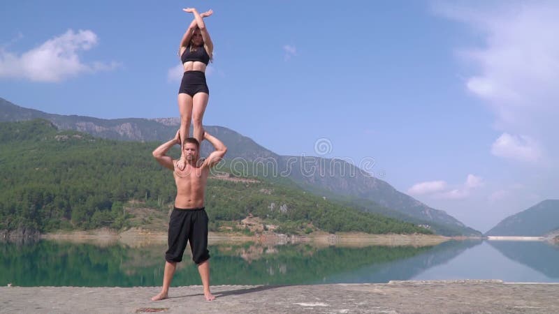 A ginasta do indivíduo guarda em seus ombros um atleta da menina