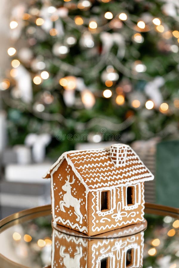 Gingerbread House On Table. Defocused Lights Of Christmas Tree. Morning In The Bright Living Room. Holiday Mood. Figure